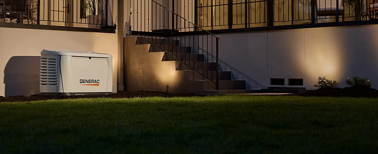 Generac home standby generator beside a house at night